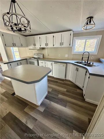 a kitchen with kitchen island a stove a sink and a refrigerator