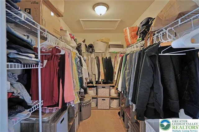 a view of walk in closet with clothes and shoes