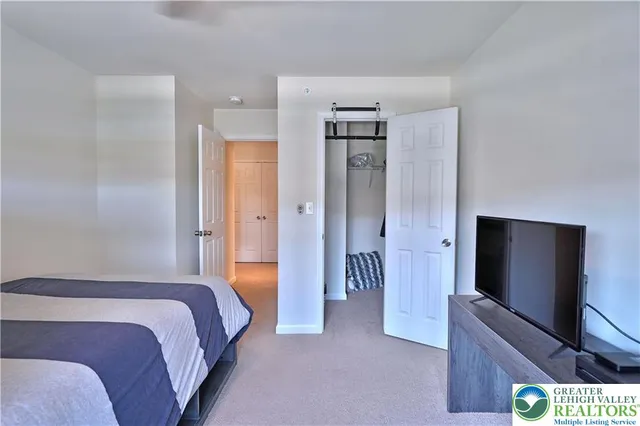 a bedroom with a bed and a flat screen tv