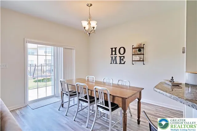 a view of a dining room with furniture wooden floor and a chandelier
