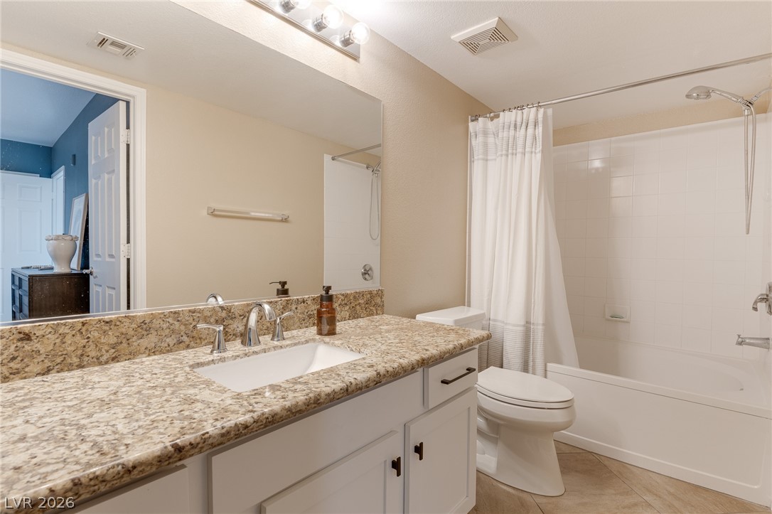 7255 West Sunset Road, Unit 2155 Las Vegas, NV 89113 - Photo 15 of 21 Bathroom with shower / bath combo with shower curtain, light tile patterned floors, and vanity