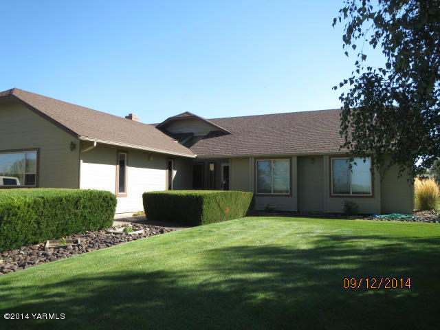 411 East Duffield Road Moxee, WA 98936 - Photo 1 of 19 a front view of a house with a yard and garage