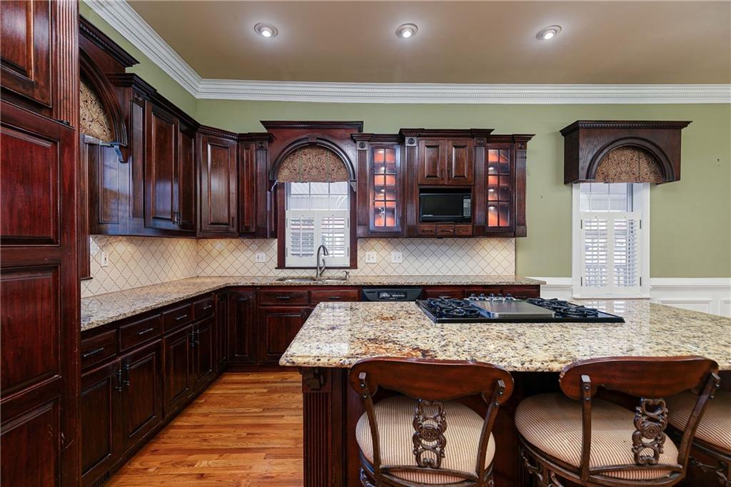 176 Confederate Avenue Dallas, GA 30132 - Photo 8 of 51 a kitchen with granite countertop a table chairs in it and wooden cabinets