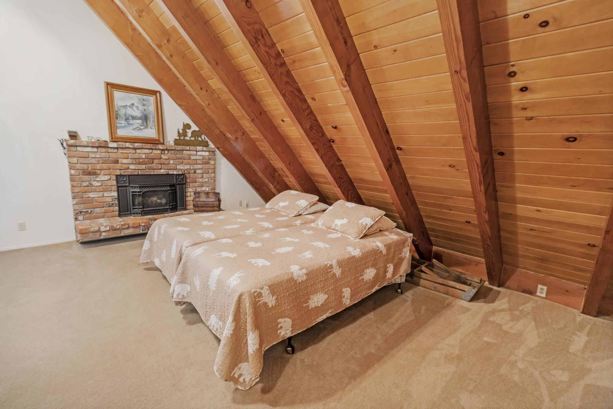 41158 Skyline Drive Emigrant Gap, CA 95715 - Photo 10 of 21 a bed sitting in a spacious bedroom next to a fireplace