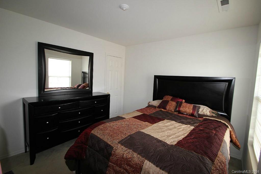 8941 Chalkstone Road Charlotte, NC 28216 - Photo 16 of 20 a bedroom with a bed and a mirror on dresser