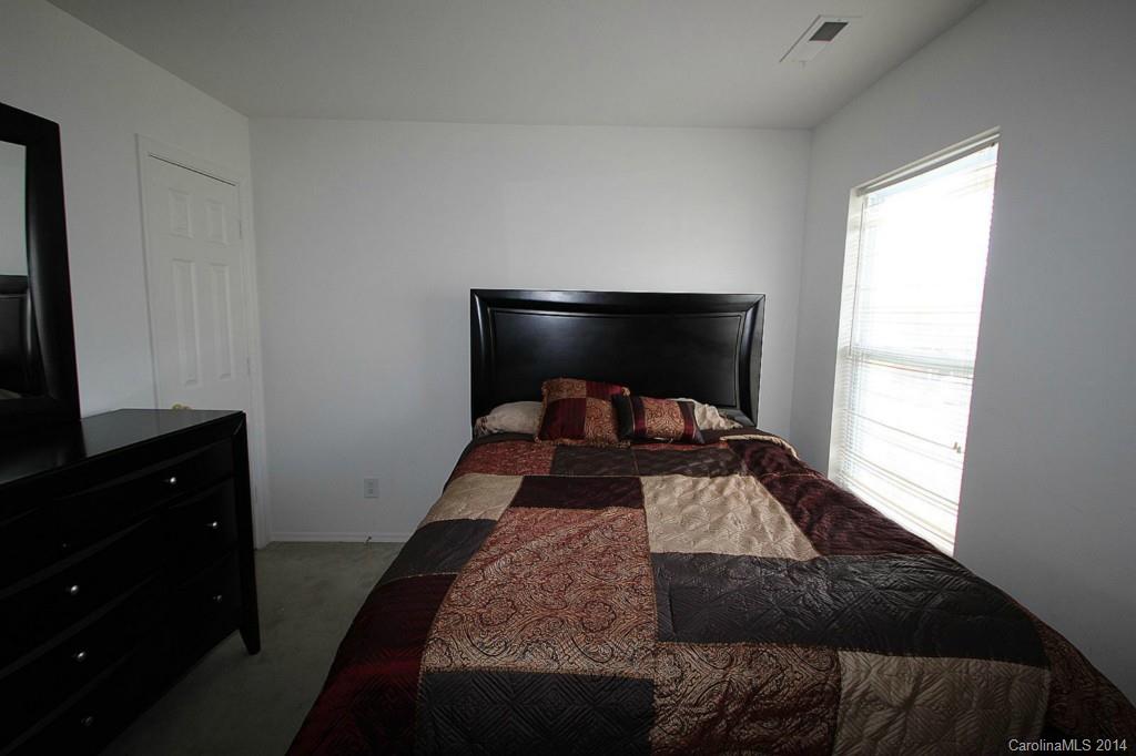 8941 Chalkstone Road Charlotte, NC 28216 - Photo 17 of 20 a bedroom with a bed and a flat tv screen on a dresser