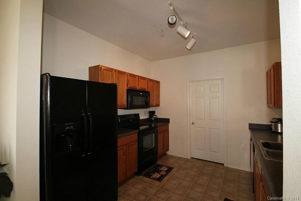 8941 Chalkstone Road Charlotte, NC 28216 - Photo 4 of 20 a kitchen with a refrigerator and a stove top oven
