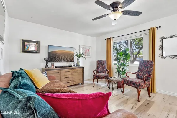 a large white kitchen with a stove oven a sink dishwasher and white cabinets with wooden floor