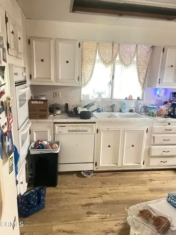a view of a kitchen with stainless steel appliances granite countertop a stove a sink and a microwave