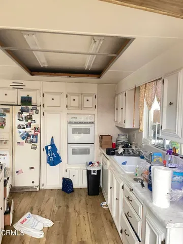 a kitchen with a refrigerator and white cabinets