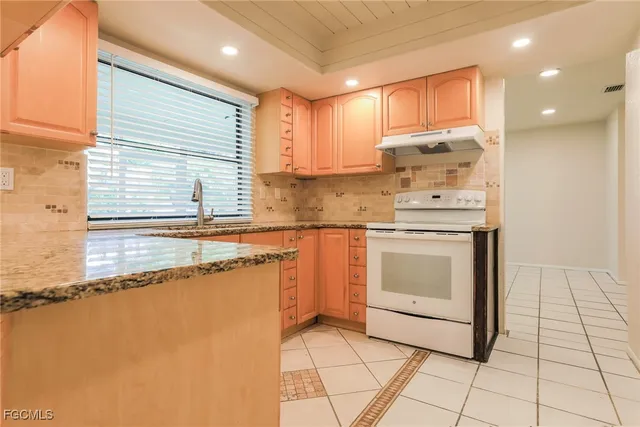 a kitchen with a stove sink and cabinets