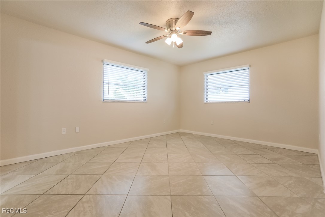 4024 Gingold Street Port Charlotte, FL 33948 - Photo 8 of 16 an empty room with windows and fan