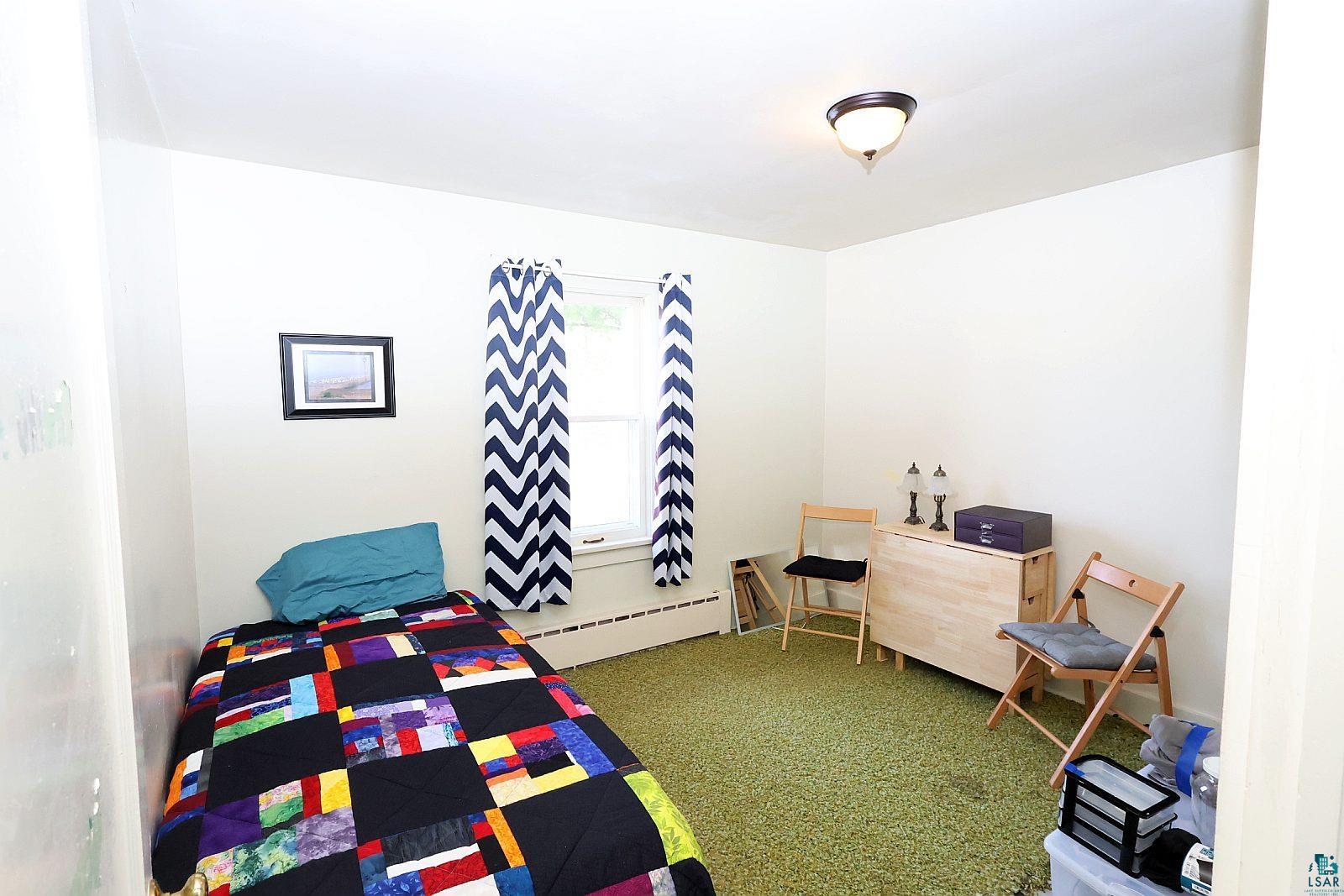 83185 Washington Avenue Port Wing, WI 54865 - Photo 17 of 26 Room featuring a window, overhead lighting, and green carpeting