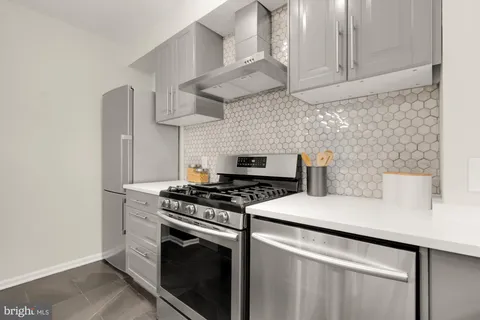 a white stove top oven sitting inside of a kitchen