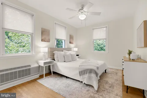a bedroom with a bed a chandelier fan and window