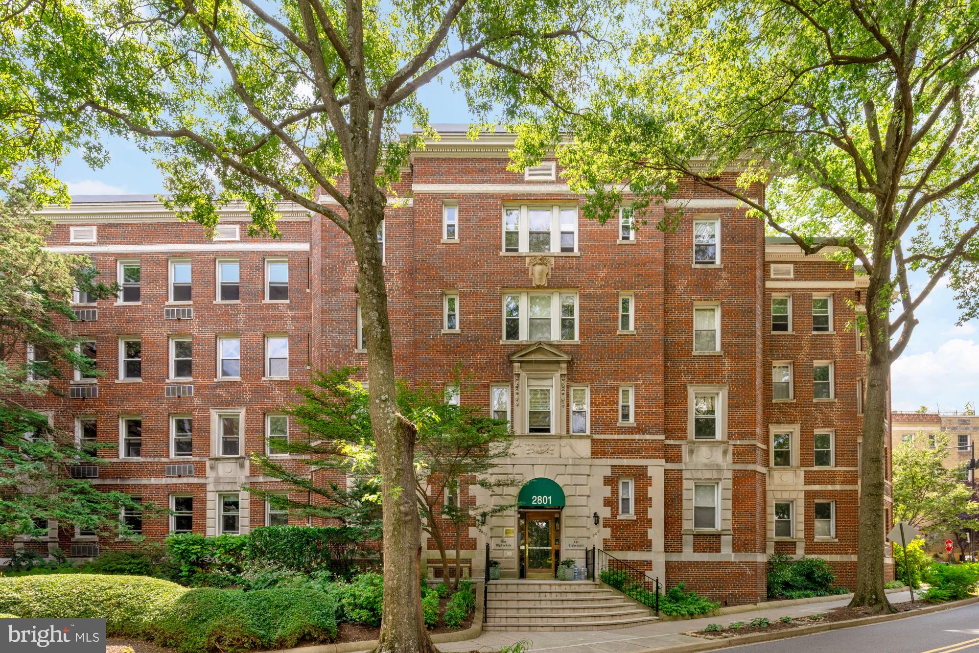 2801 Adams Mill Road Northwest, Unit 210 Washington, DC 20009 - Photo 2 of 32 a front view of a residential apartment building with a yard