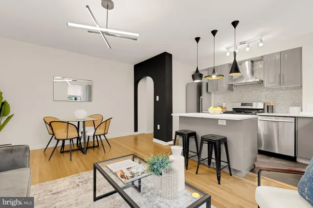 a dinning room with stainless steel appliances granite countertop furniture a fireplace a rug and a window