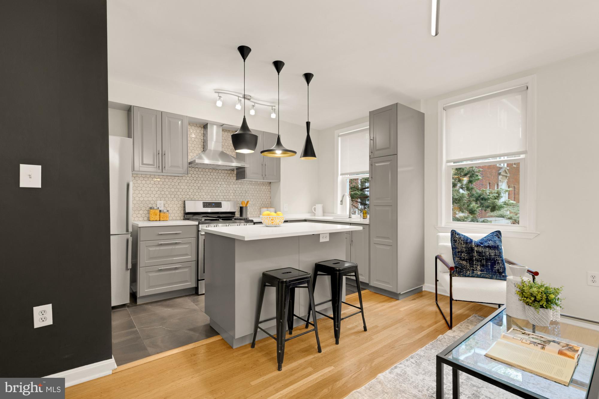 2801 Adams Mill Road Northwest, Unit 210 Washington, DC 20009 - Photo 6 of 32 a kitchen with white cabinets and stainless steel appliances with living room