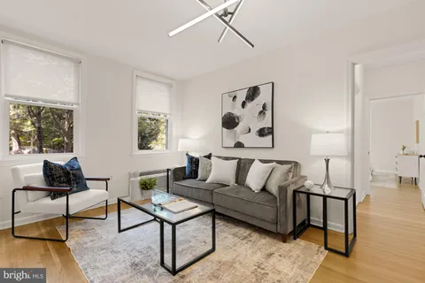 a living room with furniture and a painting on the wall