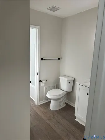 a white toilet sitting next to a bathroom sink and vanity