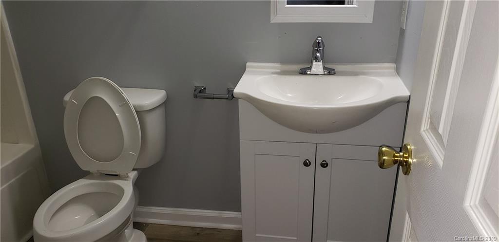 9610 Rau Court Charlotte, NC 28215 - Photo 8 of 10 a bathroom with a toilet sink and mirror