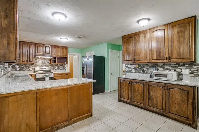 a kitchen with stainless steel appliances granite countertop a sink stove and refrigerator
