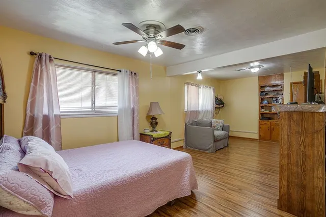 a bedroom with a bed and wooden floor