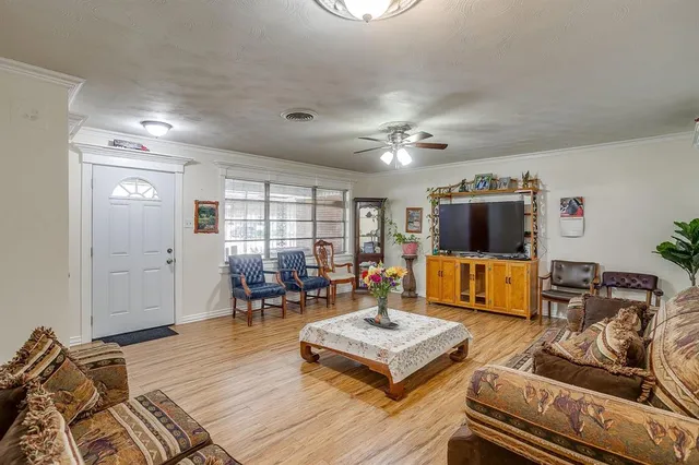 a living room with furniture a flat screen tv and kitchen view