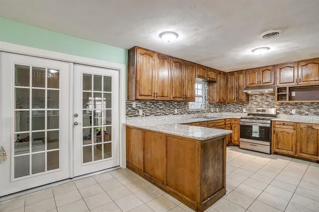 a kitchen with stainless steel appliances granite countertop a stove a sink dishwasher and a refrigerator