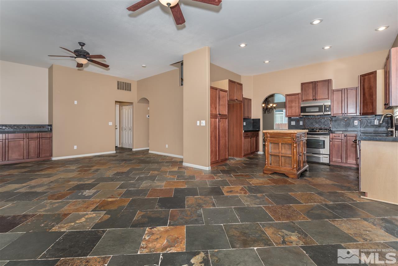 9655 Oakley Lane Reno, NV 89521 - Photo 15 of 25 a view of a kitchen with kitchen island granite countertop lots of counter top space appliances and cabinets