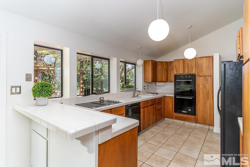 3685 Renee Way Reno, NV 89503 - Photo 8 of 26 a kitchen with stainless steel appliances granite countertop a sink and a refrigerator