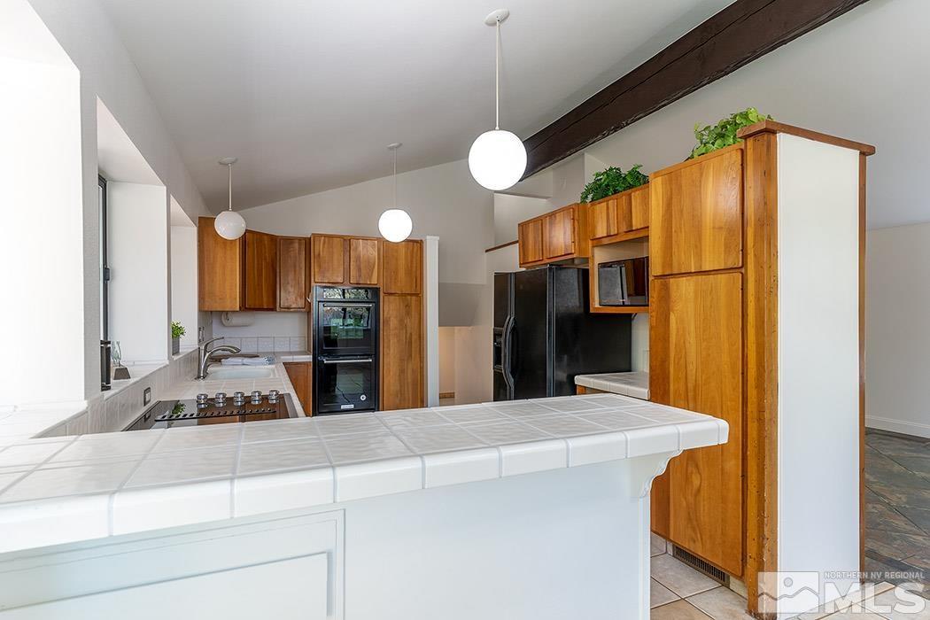 3685 Renee Way Reno, NV 89503 - Photo 9 of 26 a kitchen with stainless steel appliances a refrigerator and cabinets