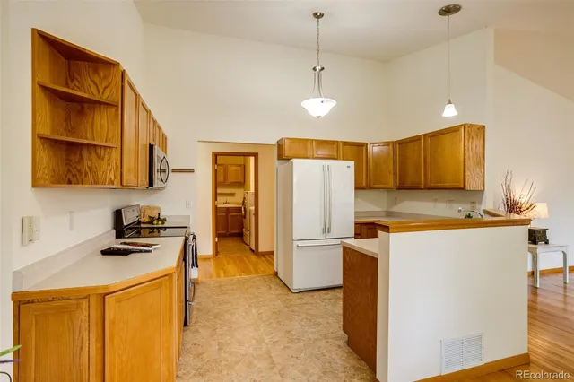 a kitchen with stainless steel appliances granite countertop a refrigerator a stove and a sink