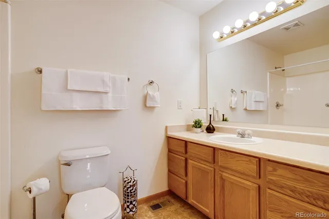 a bathroom with a toilet a sink and mirror