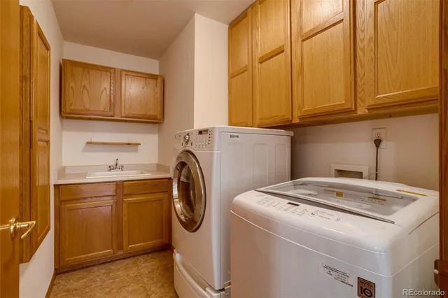 a utility room with sink dryer and washer