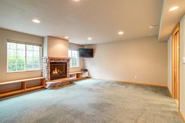 an empty room with fireplace and windows