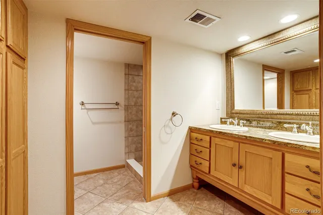 a spacious bathroom with a double vanity sink and mirror