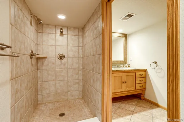 a bathroom with a granite countertop sink a mirror and shower