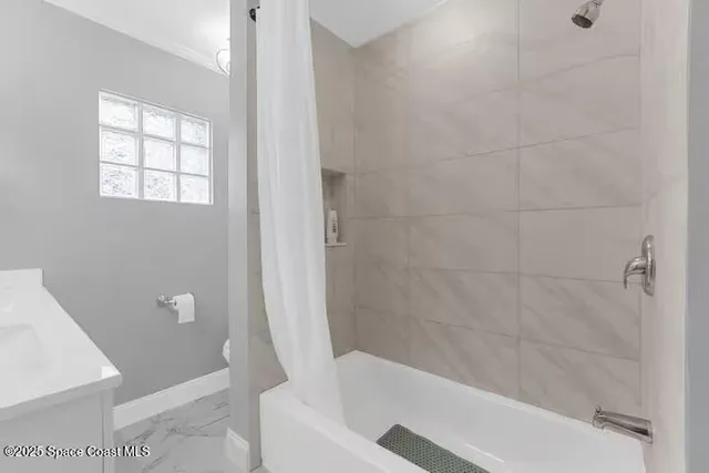 a spacious bedroom with a bed and a chandelier