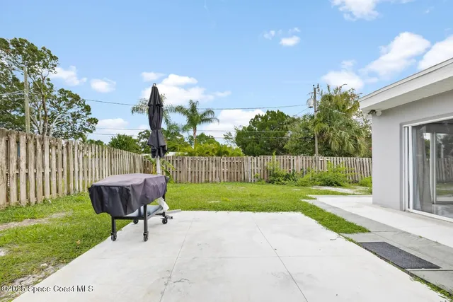 a big white house with a yard and plants