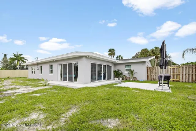 a garden with a bench in front of the house