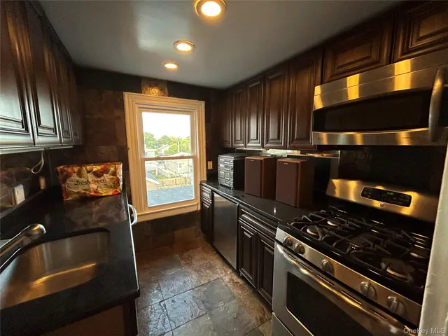 a kitchen with granite countertop a stove and a sink