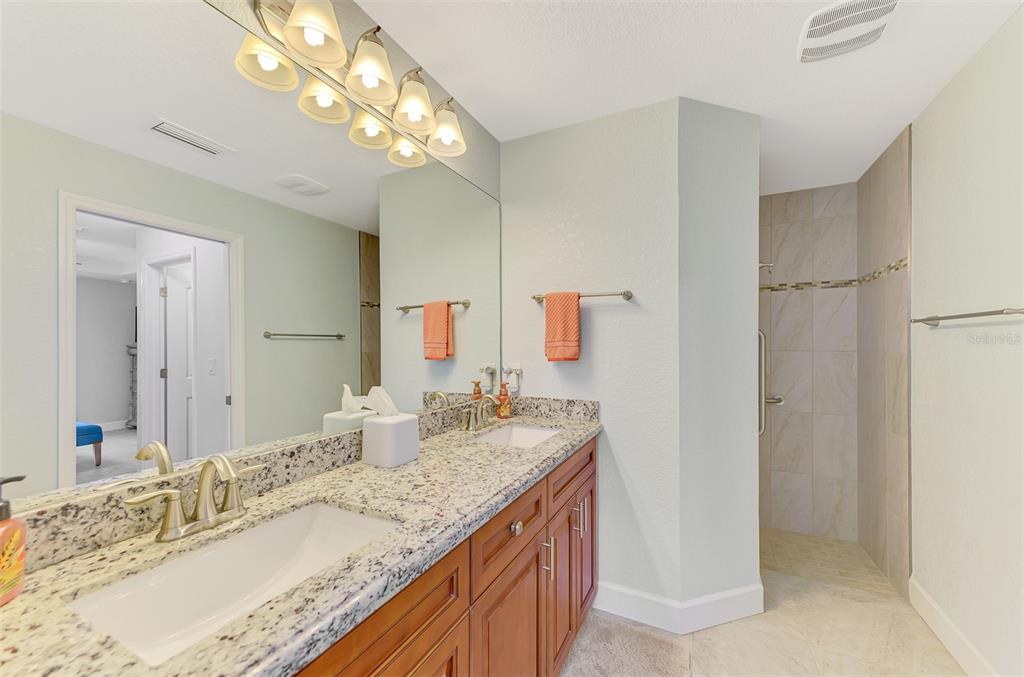 13049 Ridgely Circle Port Charlotte, FL 33981 - Photo 13 of 49 a bathroom with a granite countertop double vanity sink and a mirror