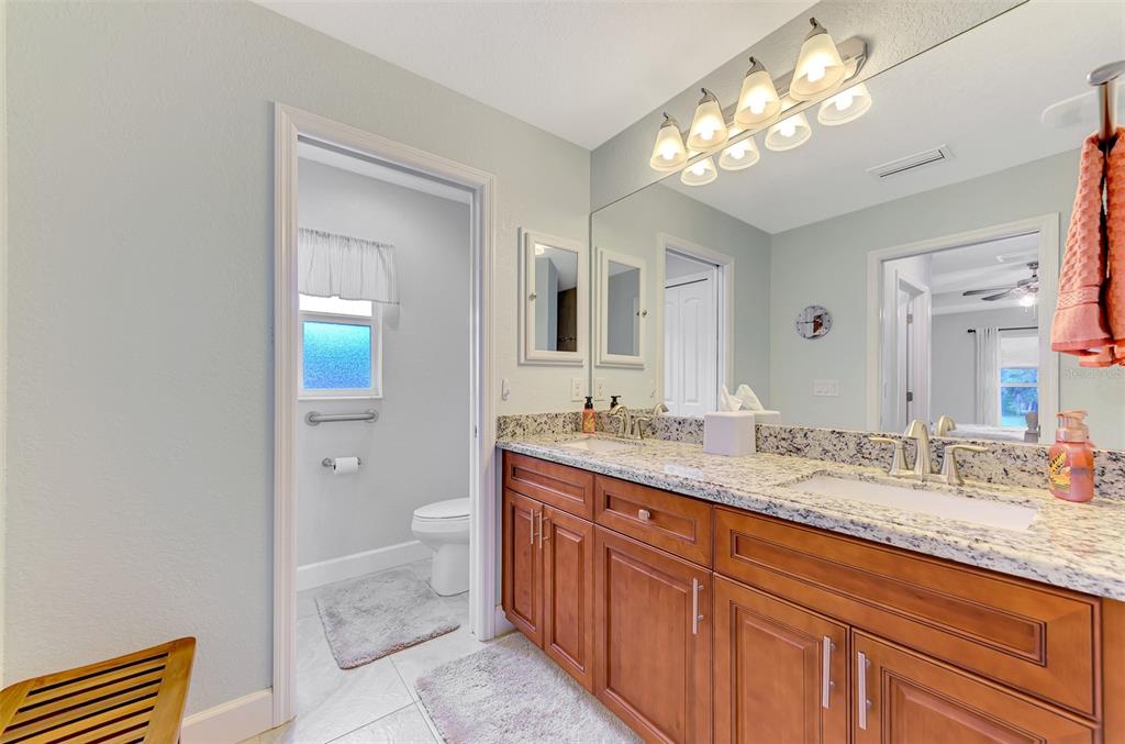 13049 Ridgely Circle Port Charlotte, FL 33981 - Photo 15 of 49 a spacious bathroom with a granite countertop sink a toilet and a mirror
