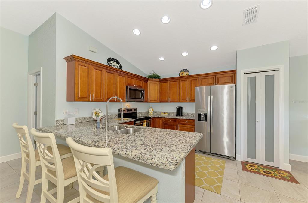 13049 Ridgely Circle Port Charlotte, FL 33981 - Photo 37 of 49 a kitchen with stainless steel appliances granite countertop a sink refrigerator and cabinets