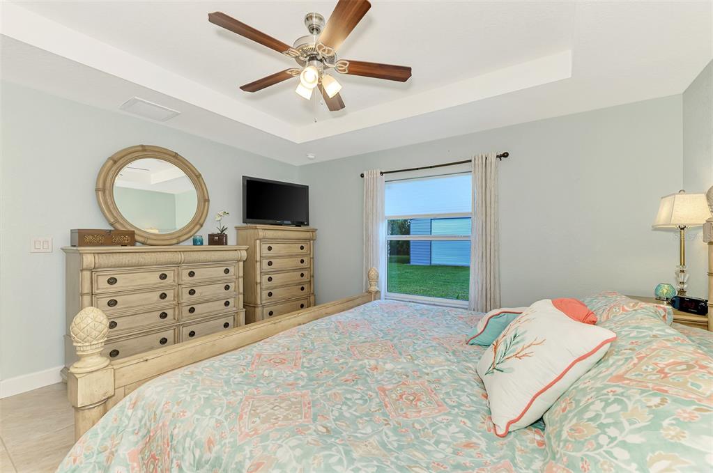 13049 Ridgely Circle Port Charlotte, FL 33981 - Photo 10 of 49 a bedroom with a bed a dresser and a chandelier