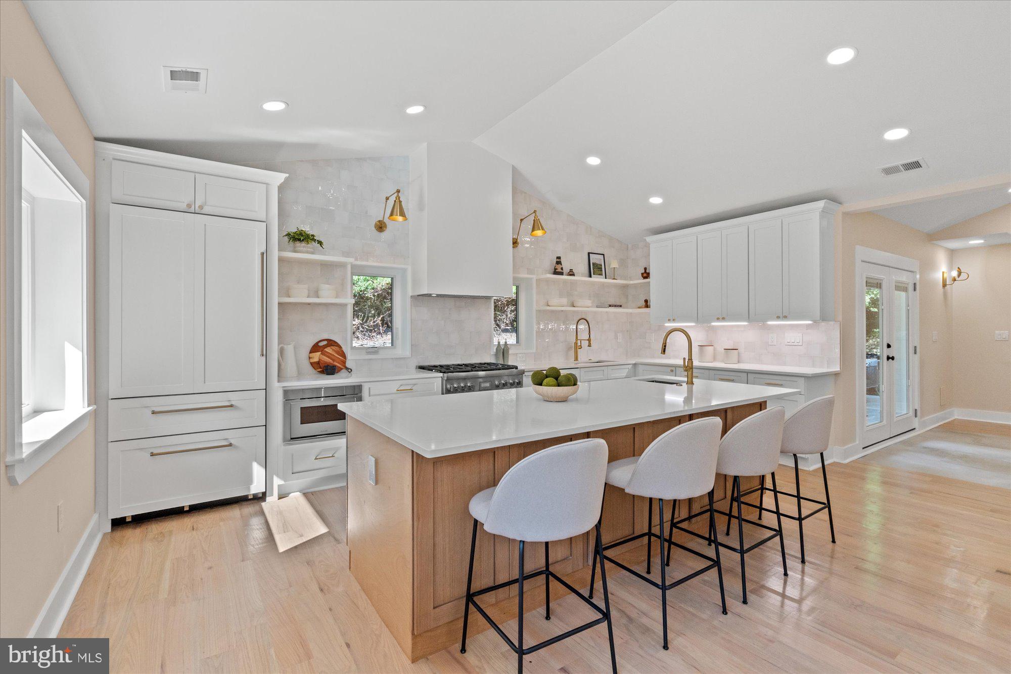 6125 Overlea Road Bethesda, MD 20816 - Photo 18 of 61 a kitchen with stainless steel appliances kitchen island granite countertop a table chairs sink and cabinets