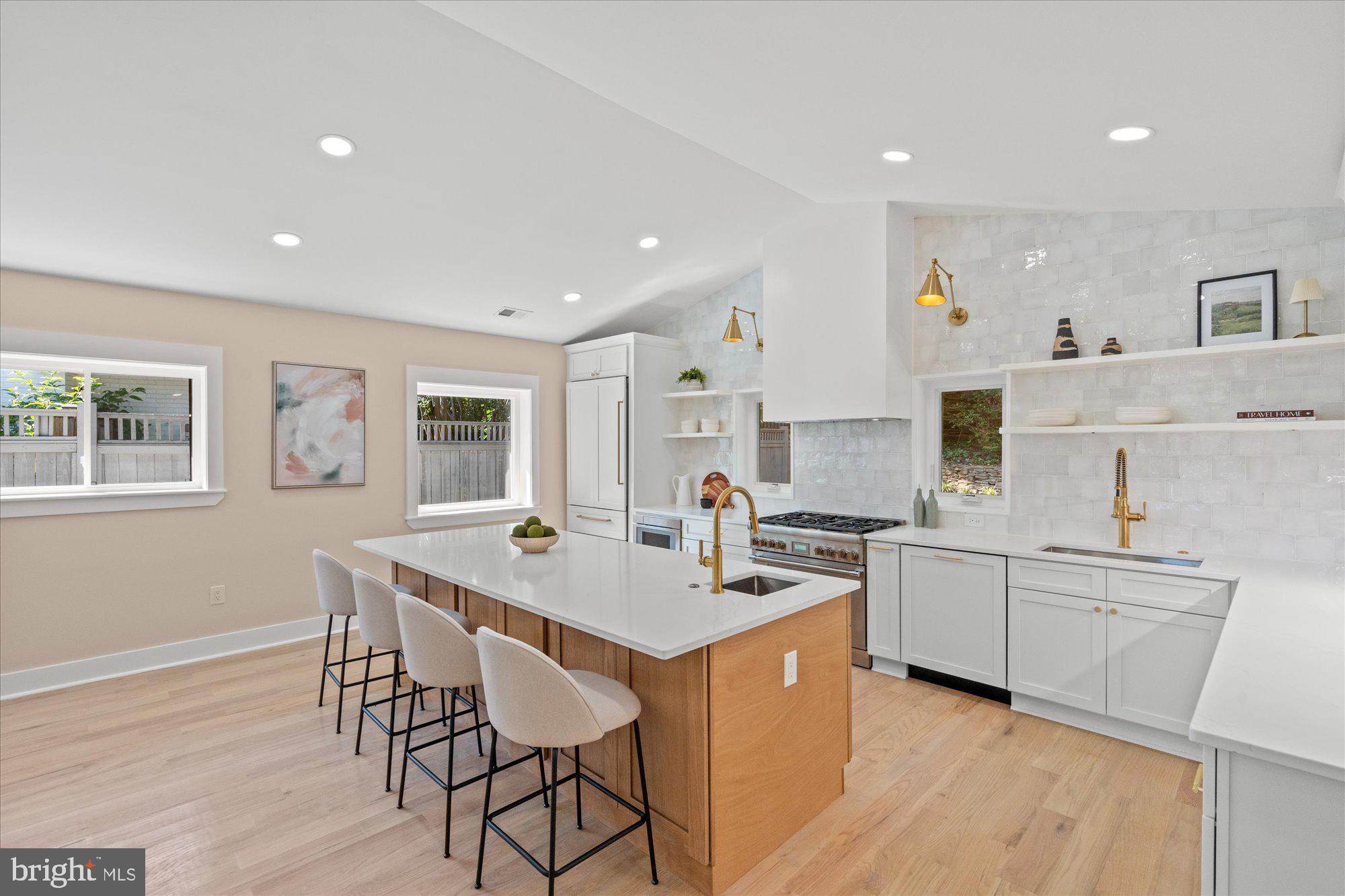 6125 Overlea Road Bethesda, MD 20816 - Photo 23 of 61 a open kitchen with stainless steel appliances granite countertop a stove top oven a sink dishwasher a dining table and chairs with wooden floor