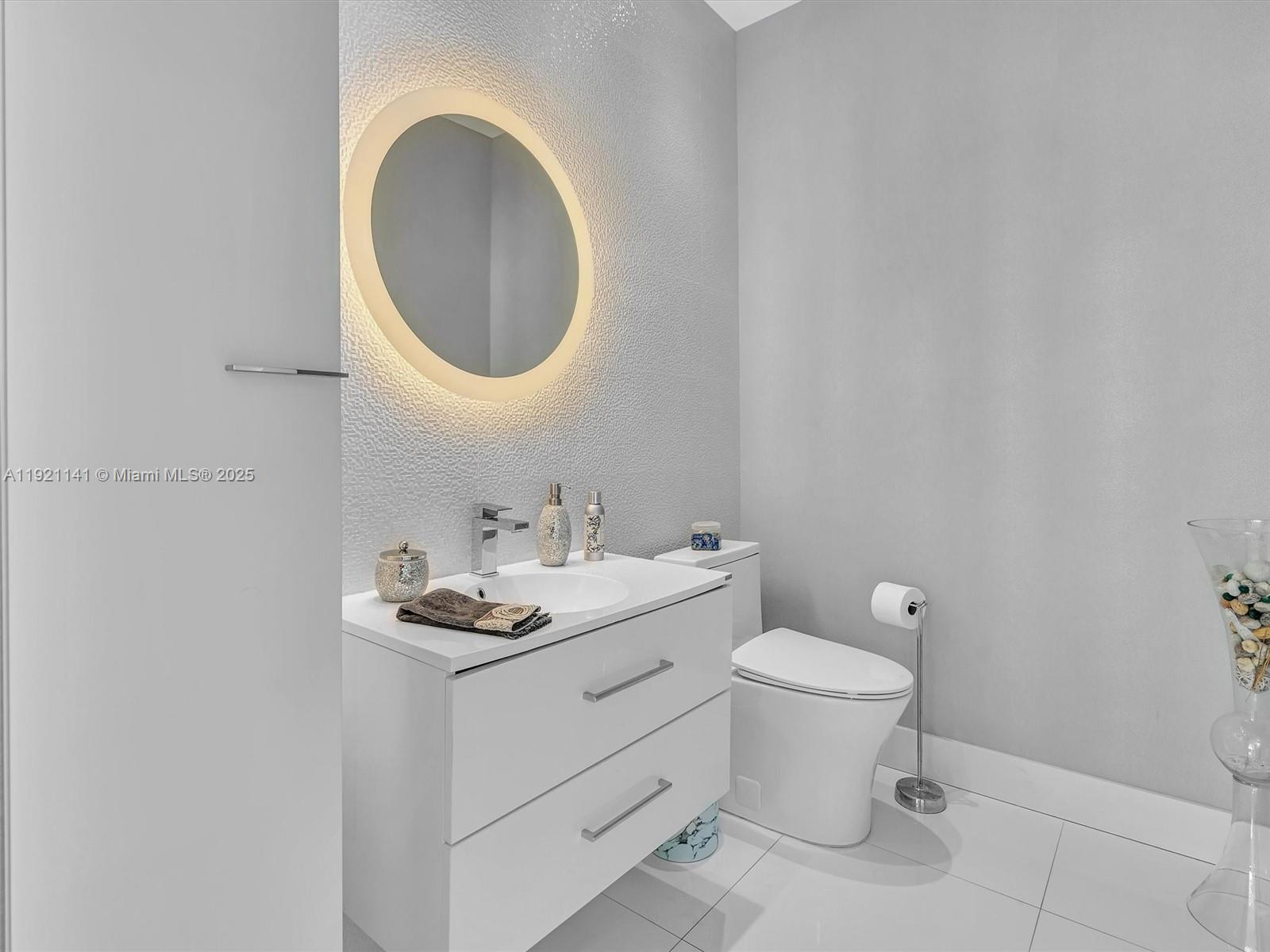 16500 Collins Avenue, Unit PH54 Sunny Isles Beach, FL 33160 - Photo 41 of 97 a bathroom with a toilet sink and mirror