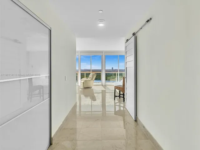 a living room with furniture and large windows